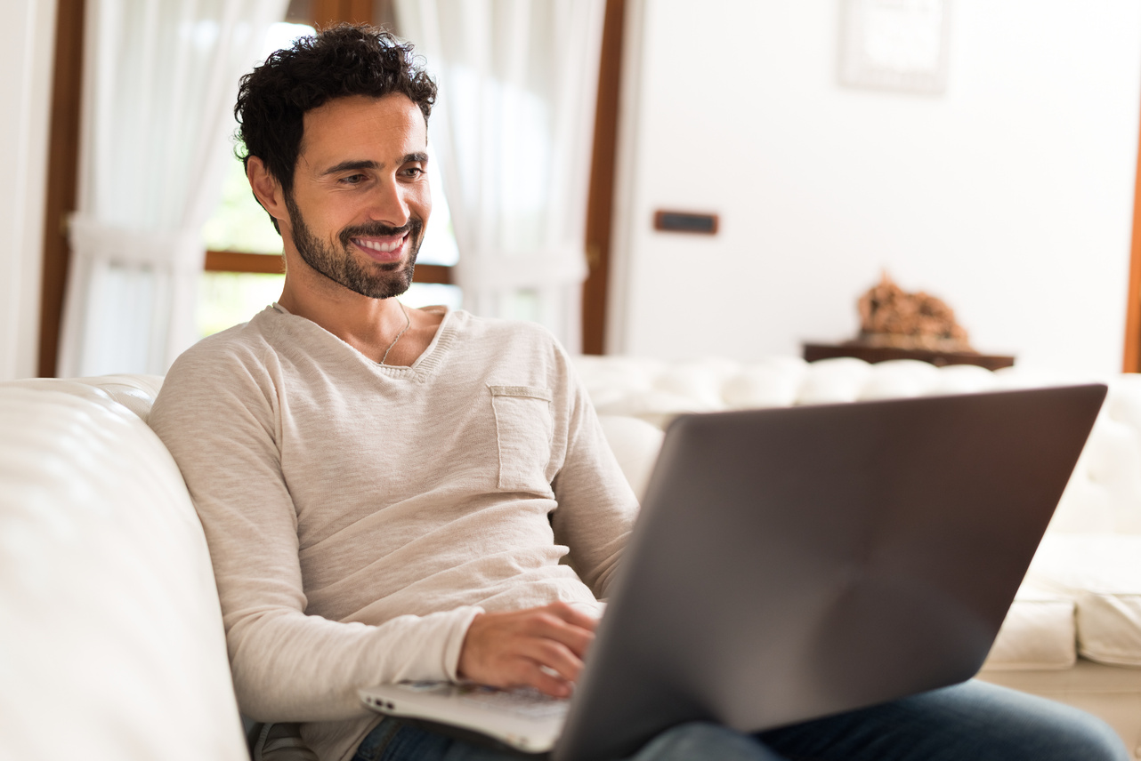 Smiling man using his laptop computer